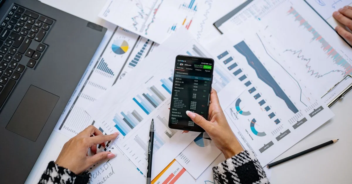 Une vue de dessus sur des graphiques et un smartphone dans un bureau, mettant en avant l'analyse de données.
