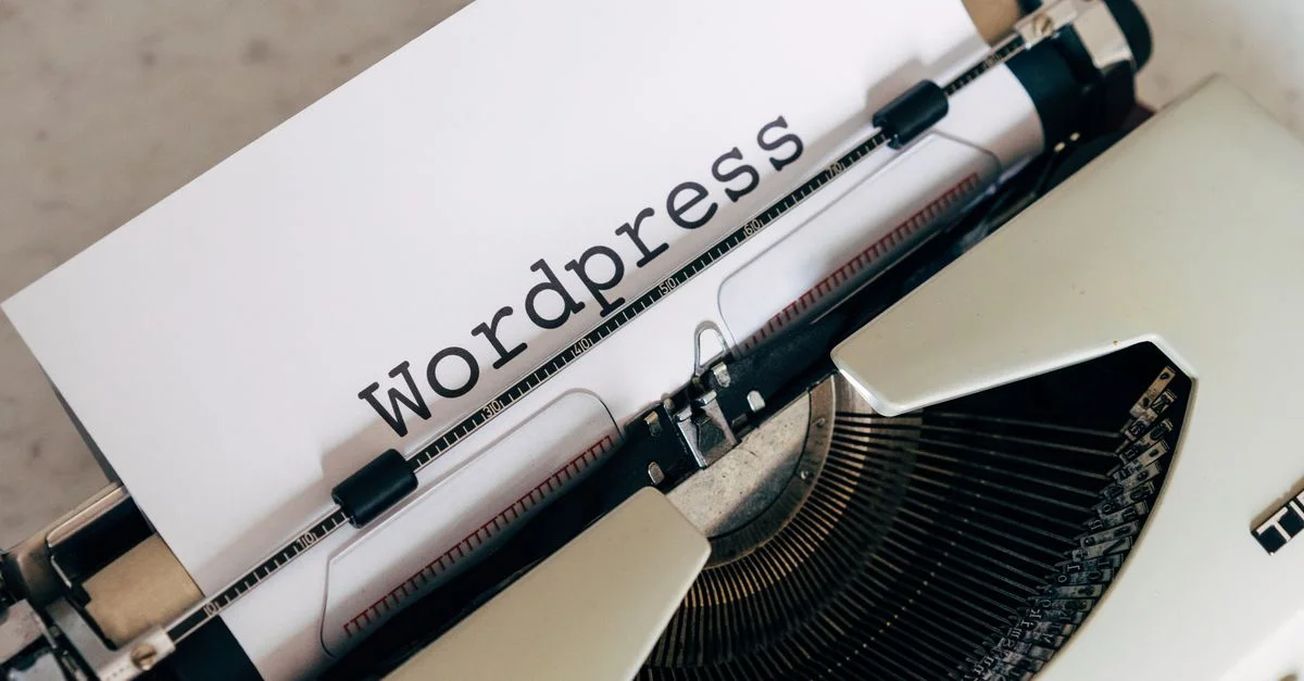 Gros plan sur une machine à écrire vintage avec un papier affichant 'WordPress', idéal pour des concepts de blog et d'écriture.