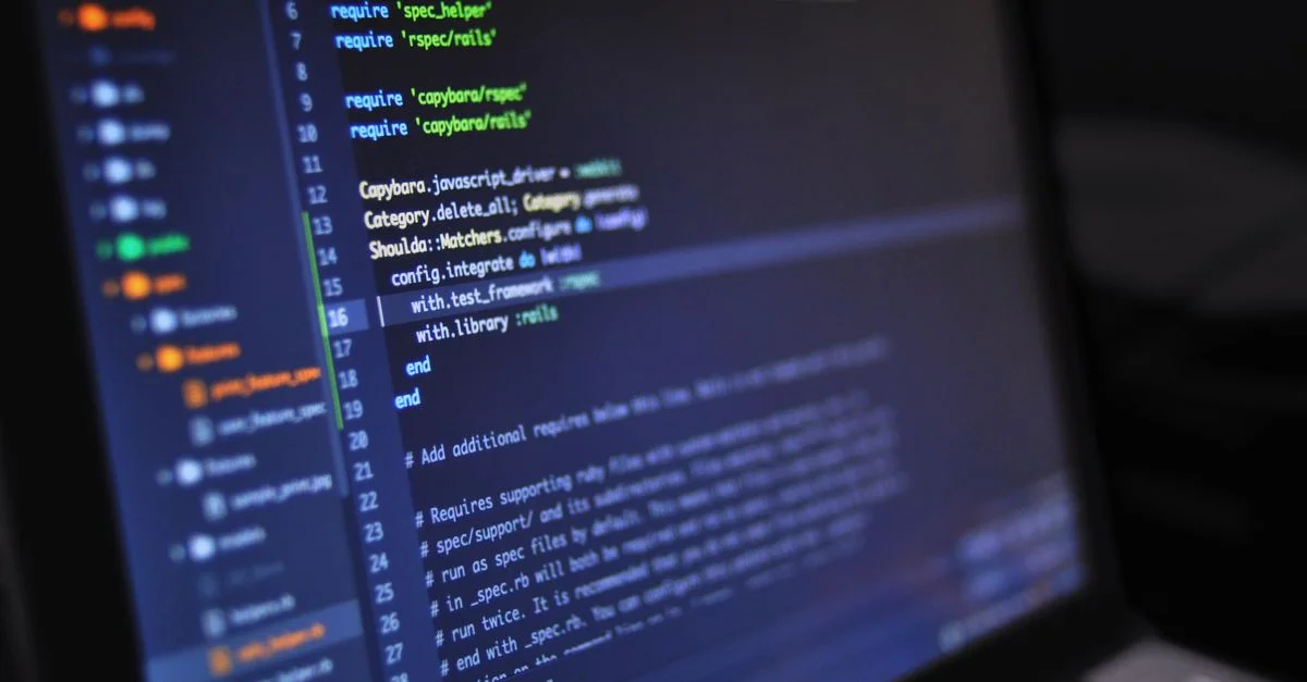 Gros plan d'un écran d'ordinateur affichant du code de programmation dans un environnement sombre.